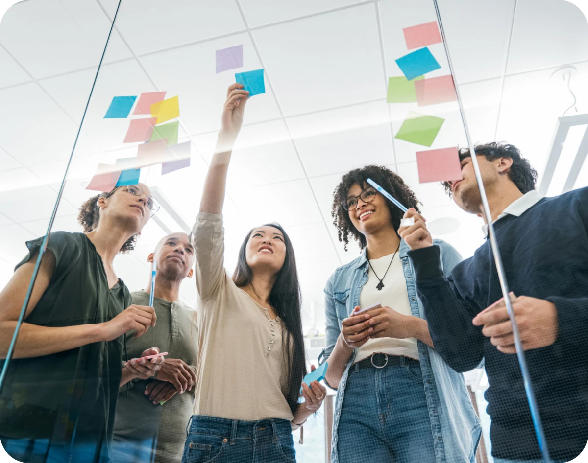 Diverse team brainstorming with sticky notes.