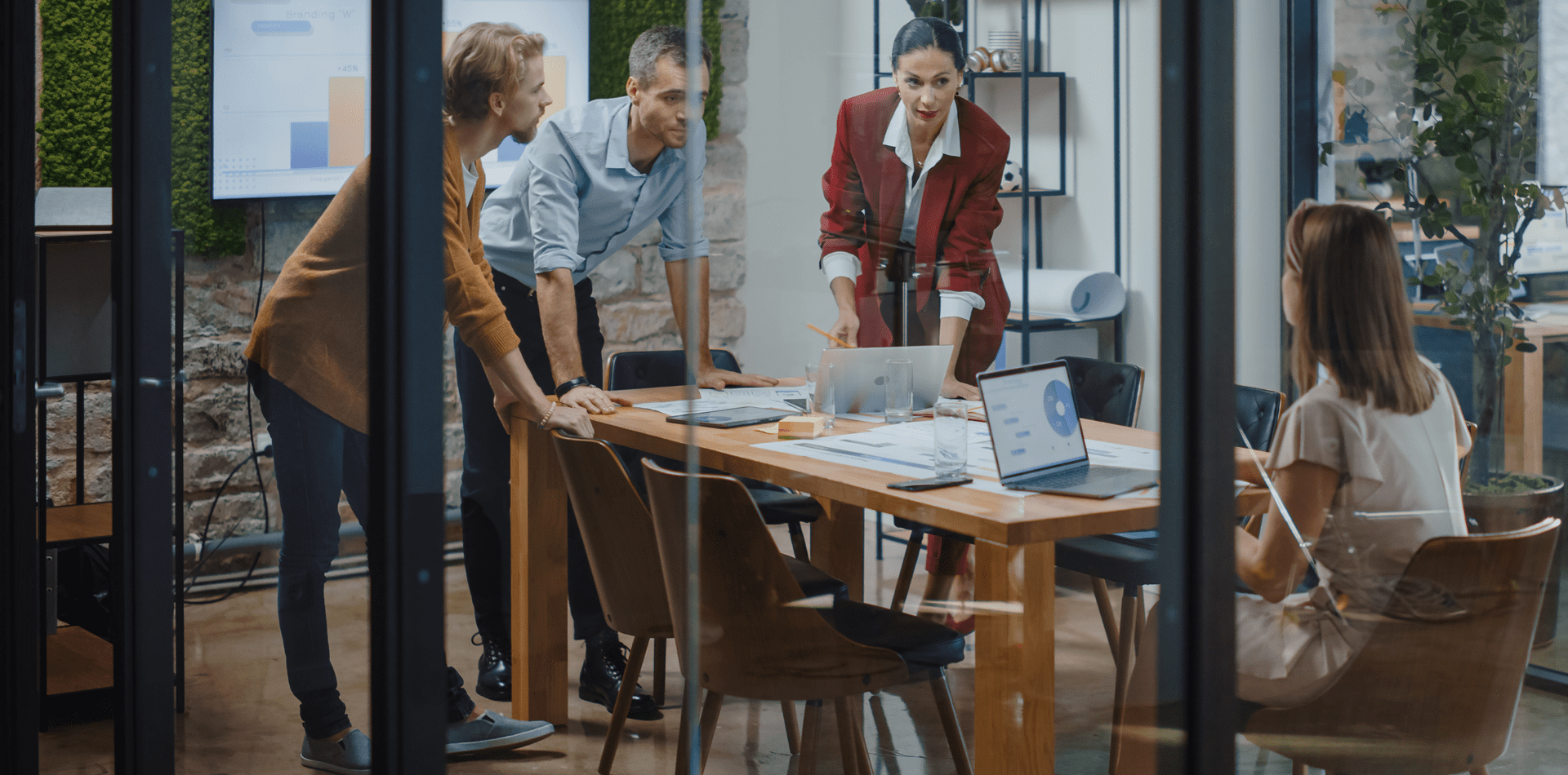 Team meeting in a modern glass-walled office.